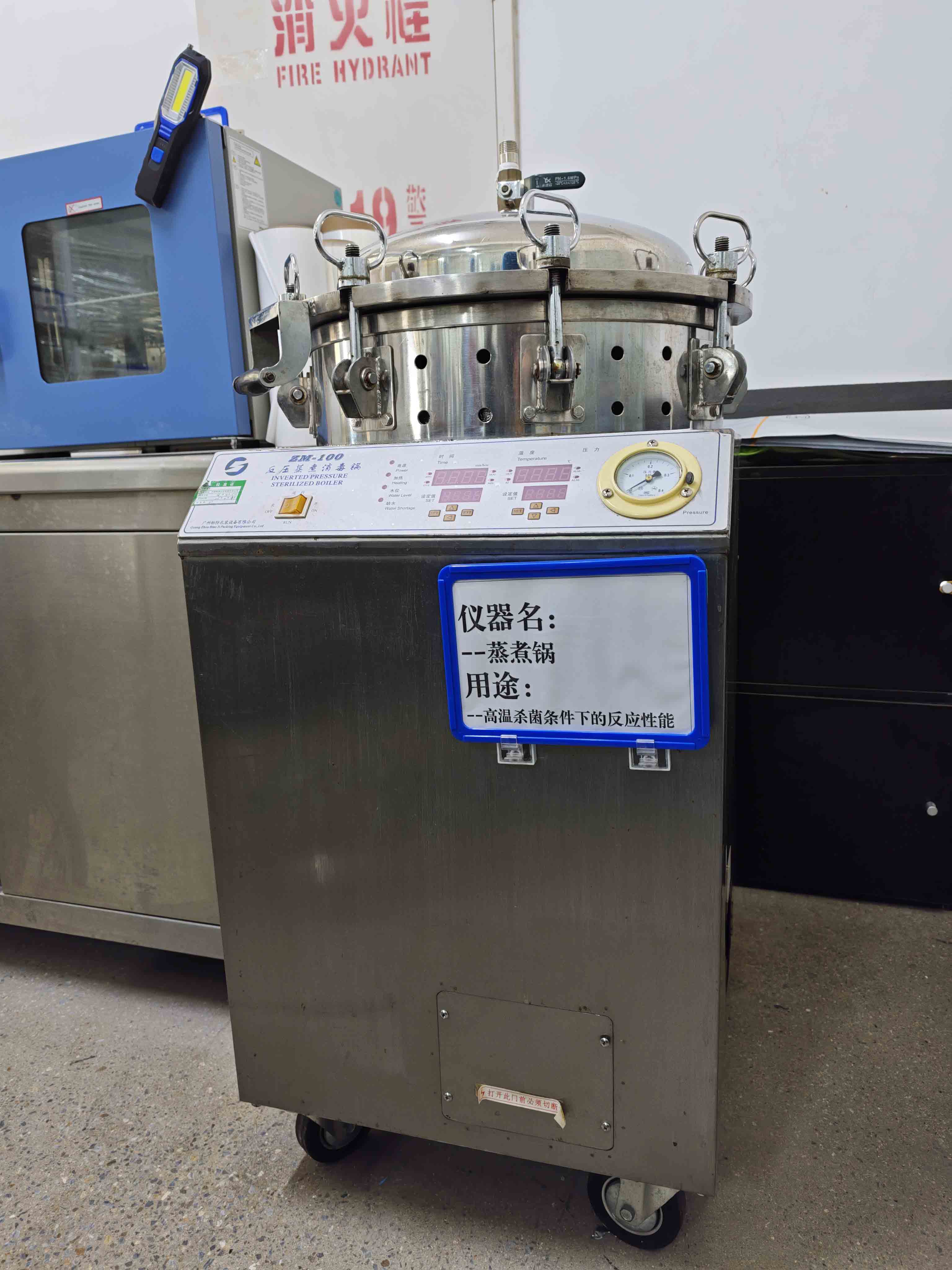 Factory retort-testing unit with a clamped vessel lid, pressure gauge and temperature controls.