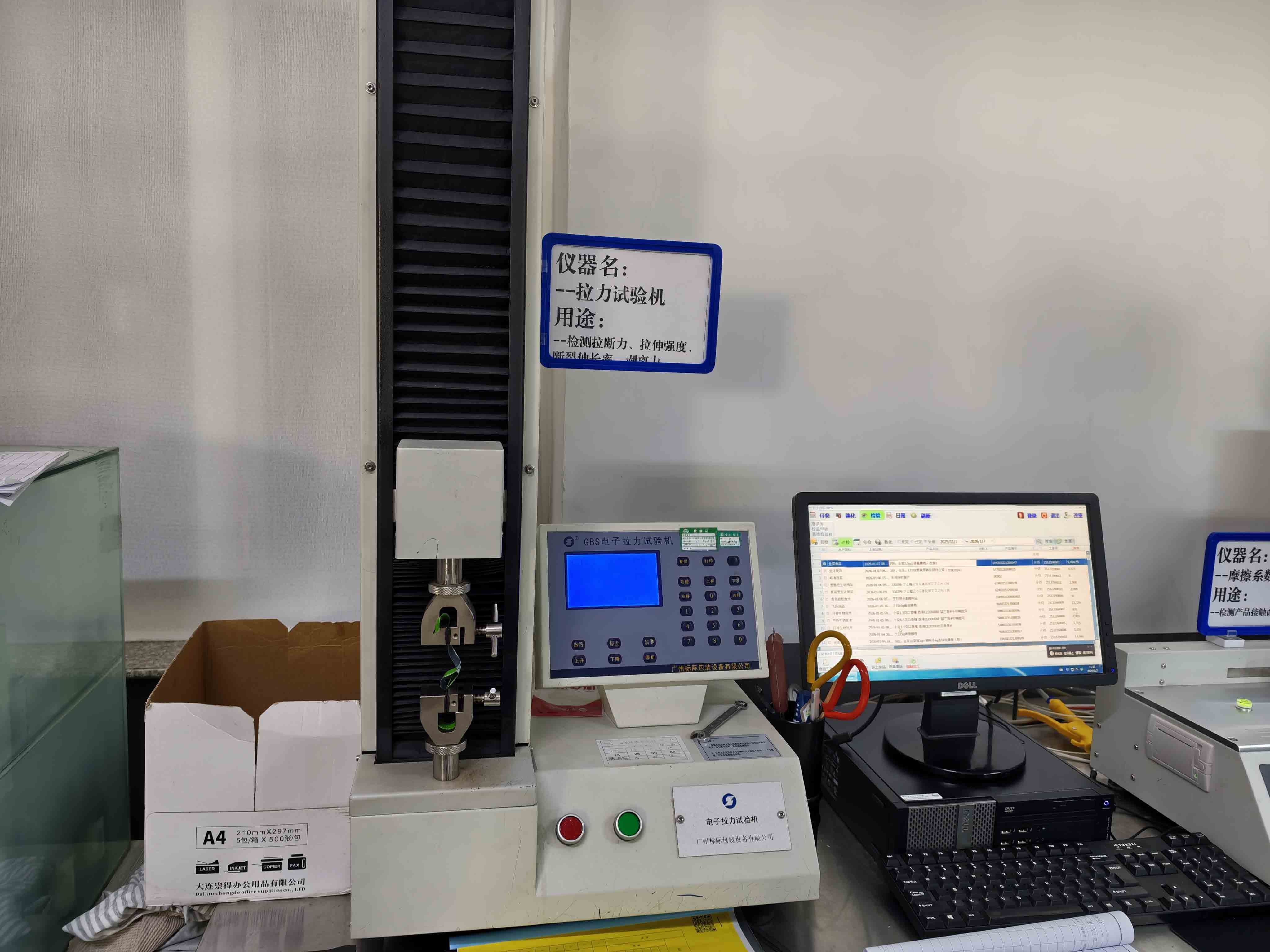 Tensile testing machine with sample grips in the Mylarbag factory laboratory.