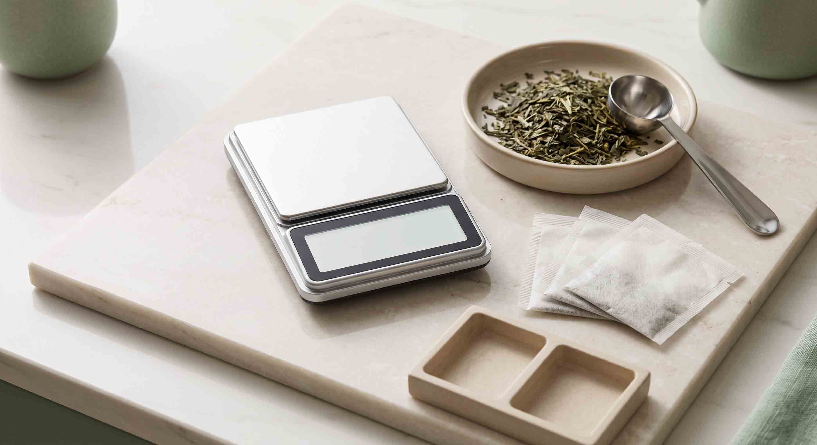 Illustrative order-planning reference of loose tea, filter bags, and a scale.