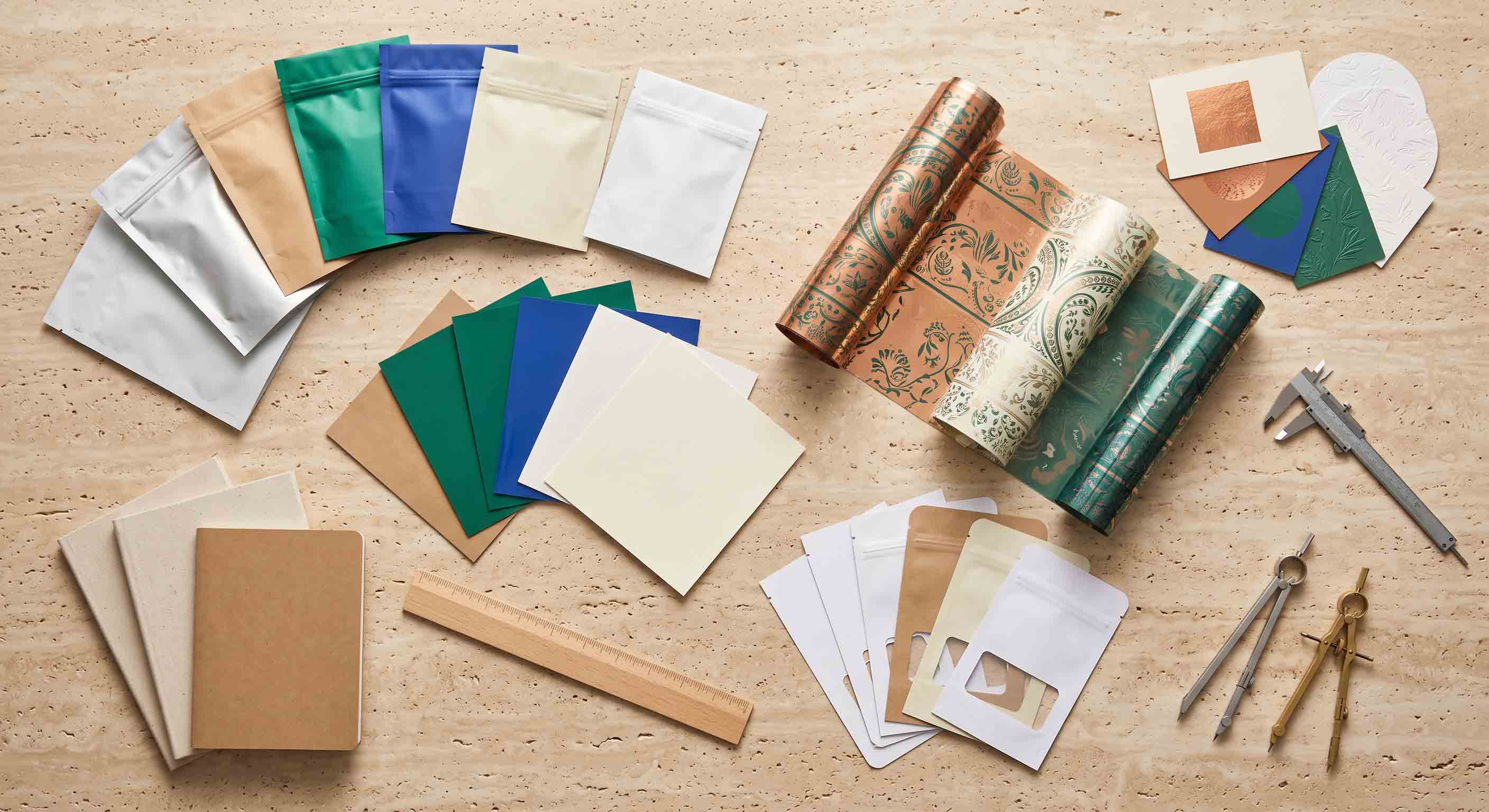 Unbranded pouch-design elements, material swatches, and flat layout samples on a worktable.